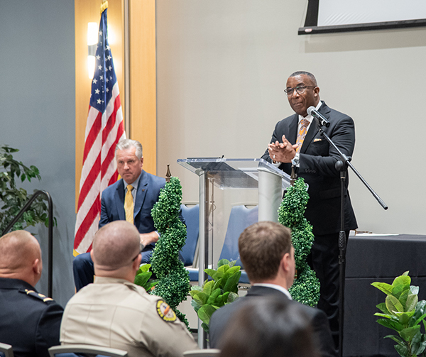 Colonel Dereck Stewart speaks to a group of law enforcement officers in an auditorium.