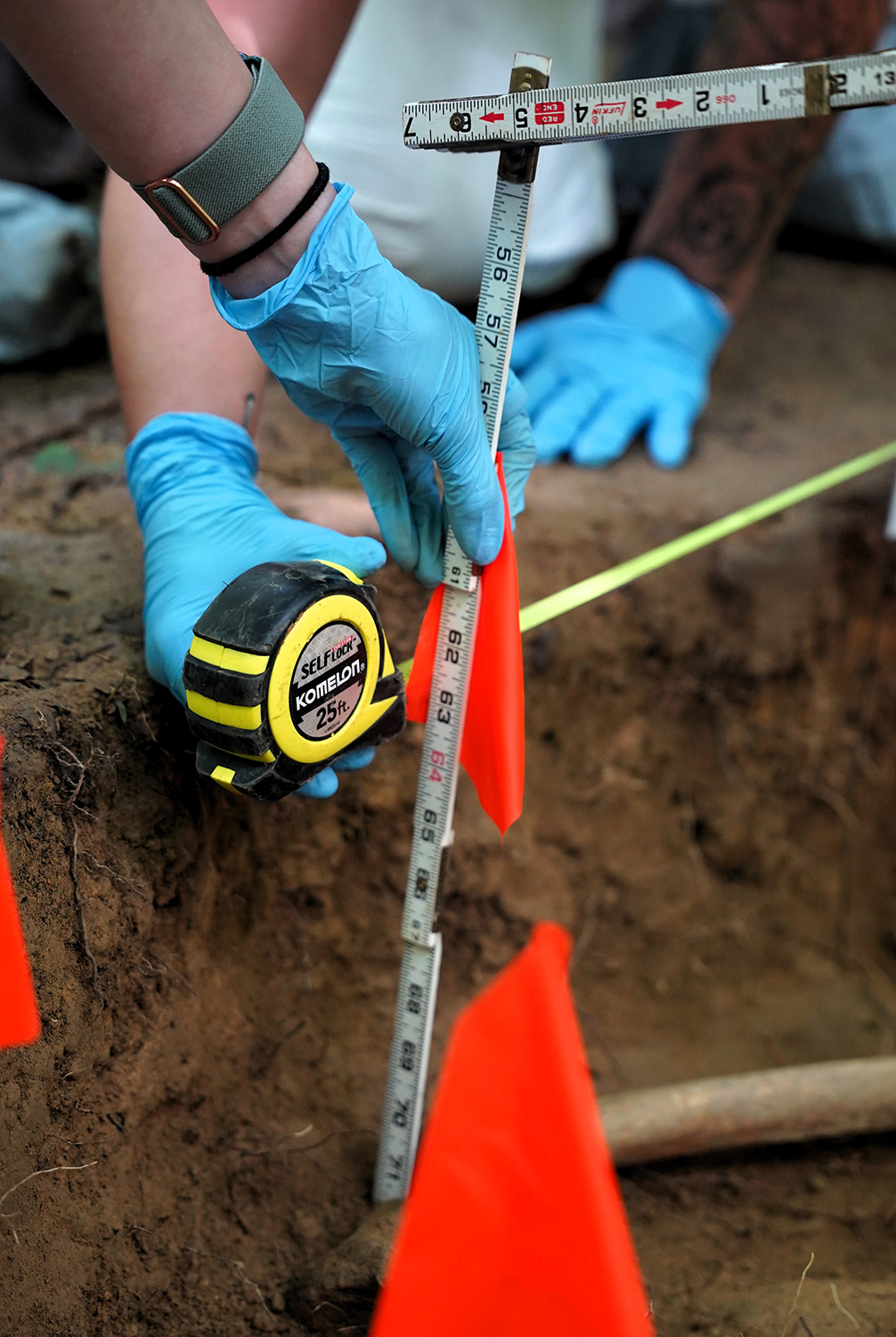 Students take measurements in a grave at a forensic science training facility.