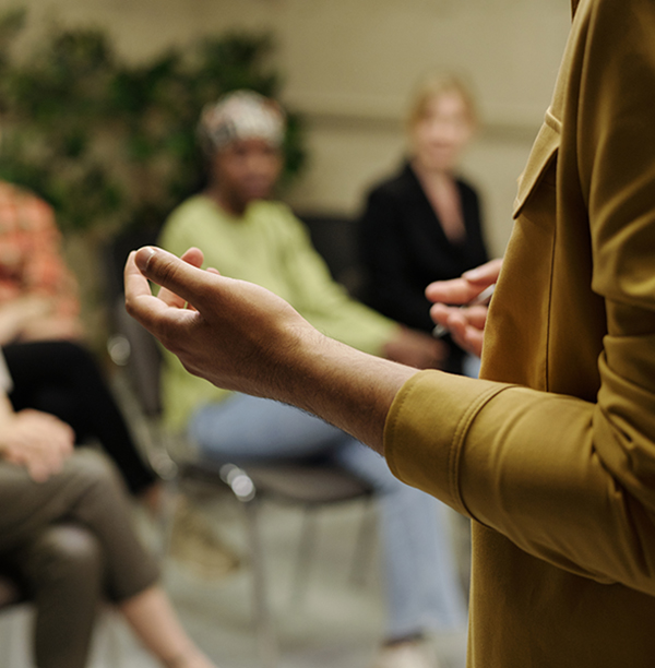 A person speaks in front of a small group seminar.