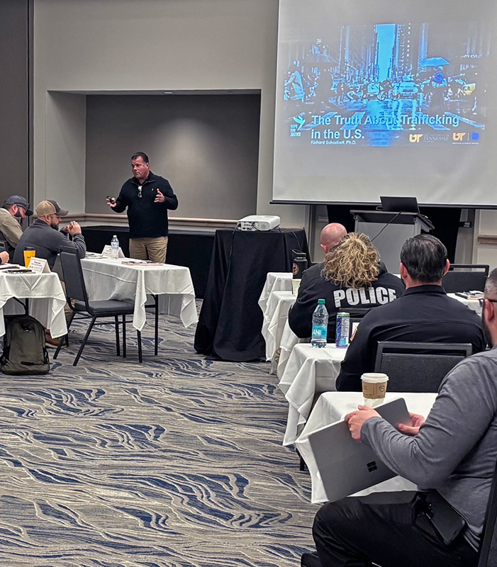 An LEIC trainer teaches the Human Trafficking course in a large hotel conference room.