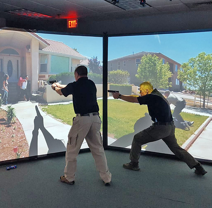 Two police officers train in a shooting simulation scenario.